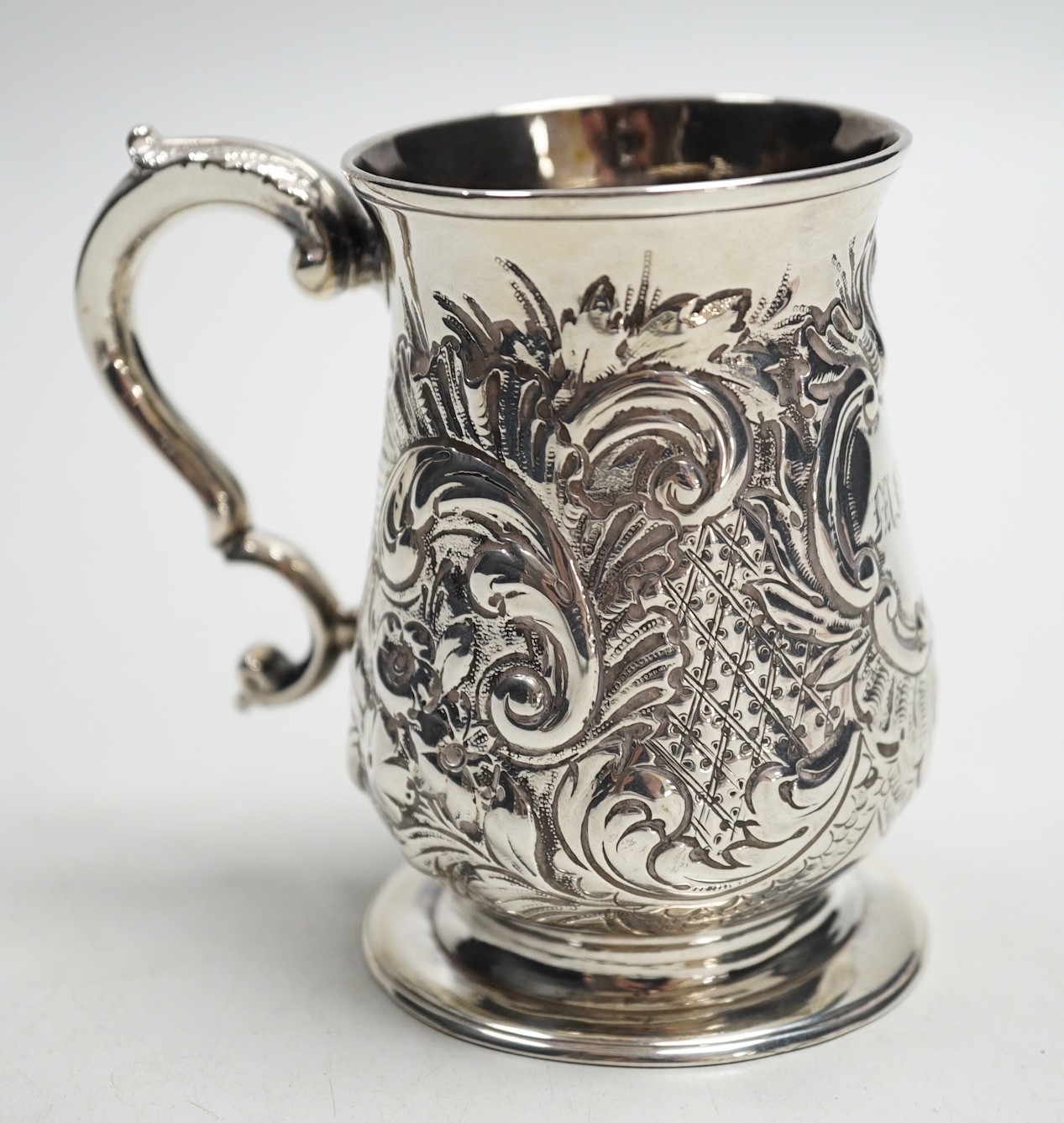 A George III silver baluster mug, with later embossed decoration, John King, London, 1775, height 93mm, 5.2oz.